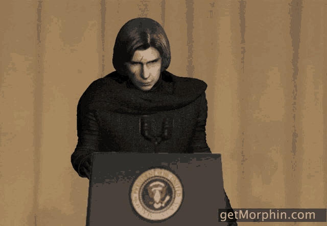 a man stands at a podium with the united states of america seal on it