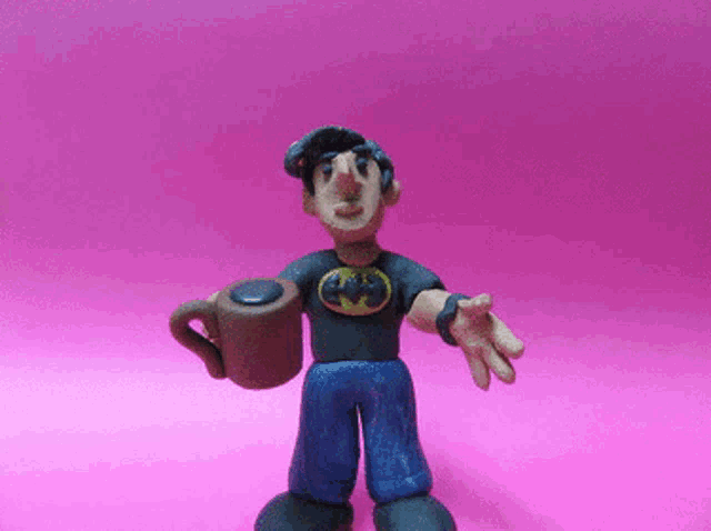 a clay figure of a man wearing a batman shirt holding a cup