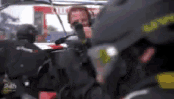 a group of people are sitting in a car and one of them is wearing a helmet that says 24h .