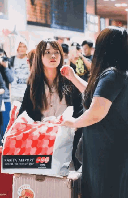 a woman holding a bag that says narita airport