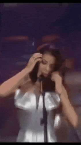 a woman is standing in front of a microphone on a stage .
