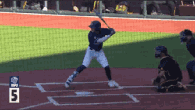 a baseball player is swinging at a pitch with the number 5 visible