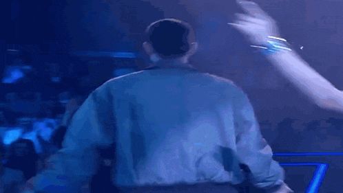 a man is standing on a stage in front of a crowd .