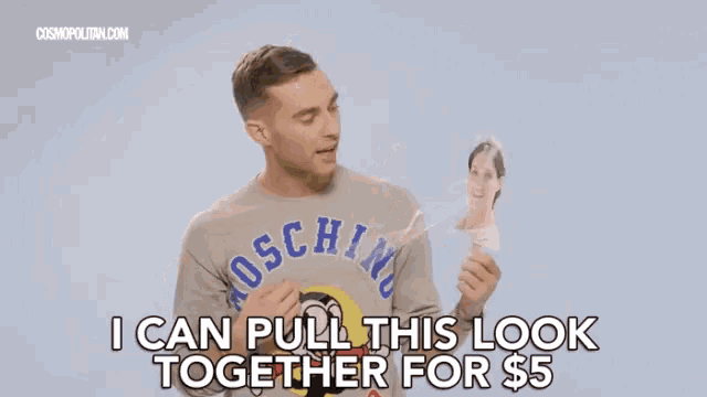 a man is wearing a moschino sweater and holding a picture of a woman