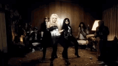 a group of people are dancing in a room with a lamp
