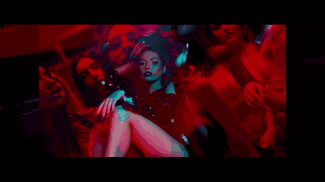 a woman in a red dress is surrounded by people