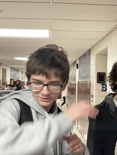 a boy in a hallway with a sign on the wall that says b