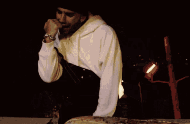 a man with a beard wearing a white hoodie and a black beanie