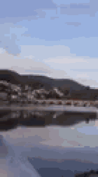 a blurred picture of a lake with mountains in the background .