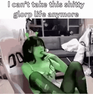a girl in a shrek costume is sitting in a chair with her legs crossed .