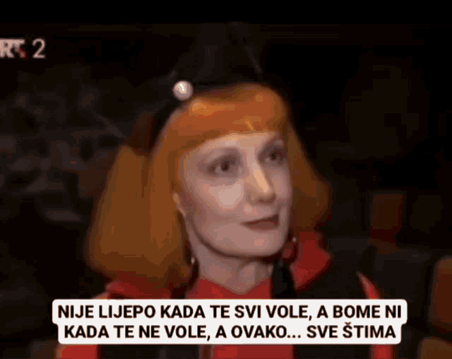a woman with orange hair is on a tv screen with a caption that says nije lijepo kada te svi vole