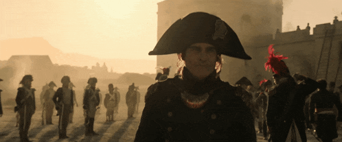 a man in a napoleon hat stands in front of a crowd of people