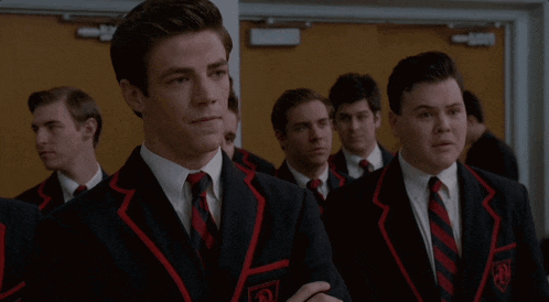 a group of men in suits and ties are standing in a line