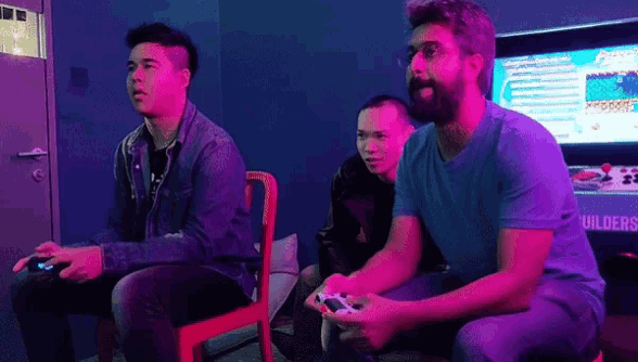 a group of men are playing a video game in front of a screen that says builders