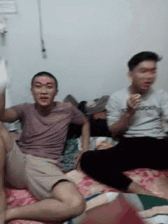 two men are sitting on a bed with red paint on their faces .