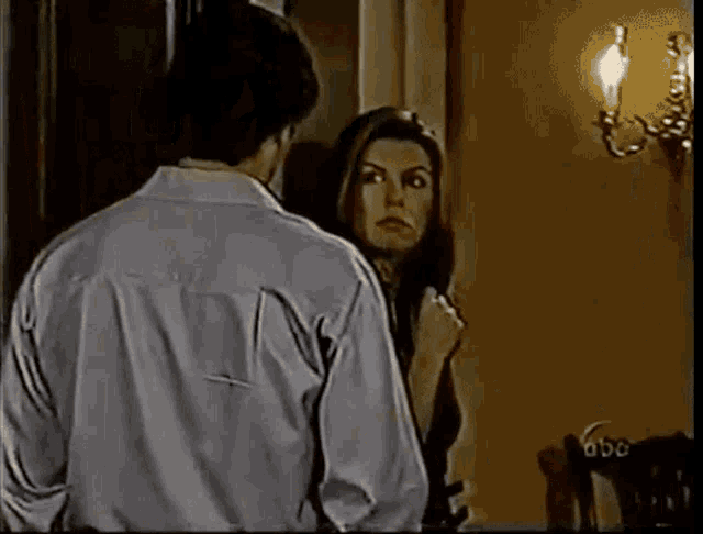 a man and a woman are standing next to each other in front of a candle .