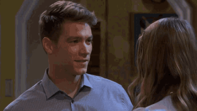 a woman is smiling while looking at a man in a dark room .