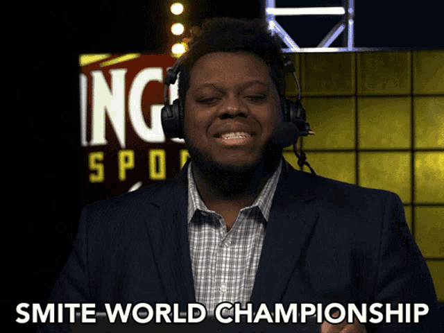 a man in a suit and headphones says " smite world championship "