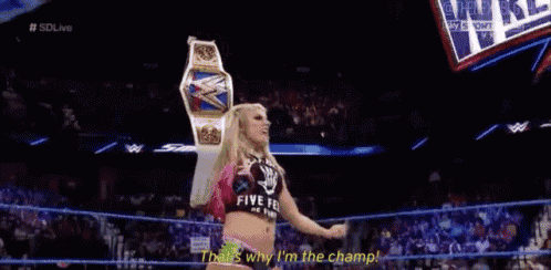 a woman standing in a wrestling ring with the words that 's why i 'm the champ