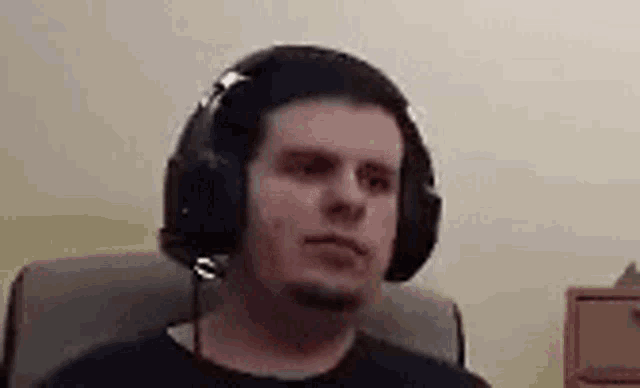 a man wearing headphones is sitting in a chair in a room .