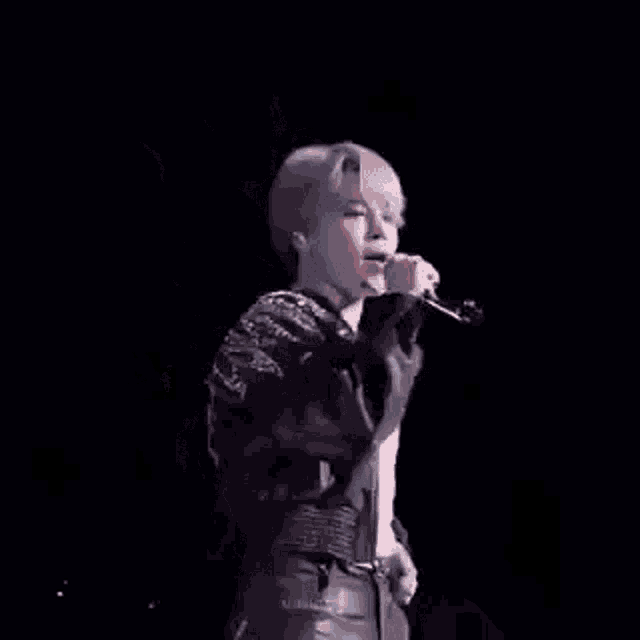 a person is singing into a microphone on a stage .