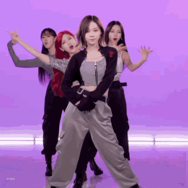 a group of girls are dancing in front of a purple background and the word xhan is on the bottom