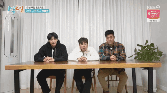three men sit at a table with a kbs logo on the bottom left
