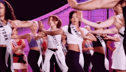 a group of women are dancing together on a stage in a dance studio .