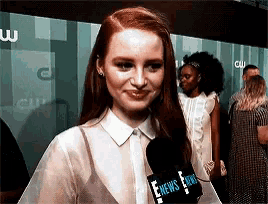 a woman is talking into a microphone that says enews .