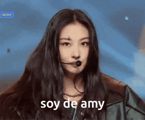 a woman with a microphone in her mouth and the words soy de amy above her
