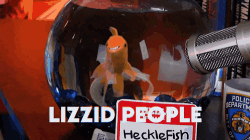 a goldfish in a bowl next to a sign that says hecklefish