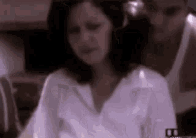 a woman in a white shirt is sitting in front of a man in a white shirt .