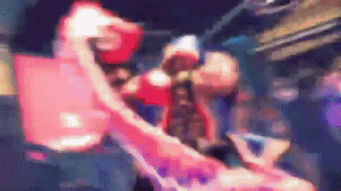 a blurry picture of a person wearing boxing gloves and a red hood .