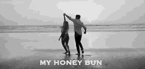 a man and a woman are dancing on a beach .