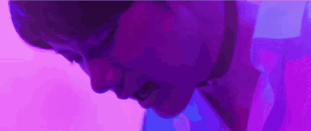 a close up of a person 's face with a purple background .