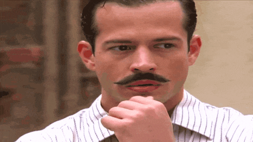 a man with a mustache and a striped shirt is thinking
