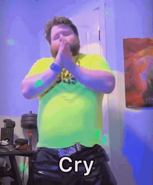 a man in a yellow shirt is dancing with the word cry written on his pants