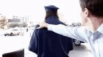 a man is holding a woman in a cap and gown .