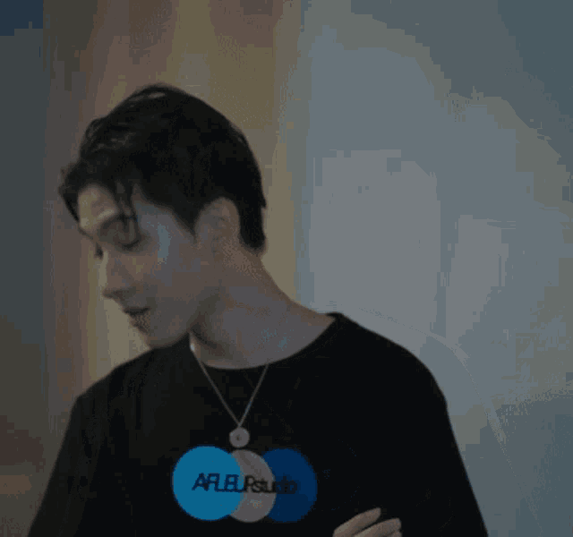 a man wearing a black t-shirt that says arfleurstudio