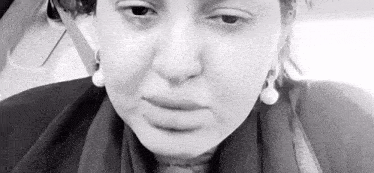 a close up of a woman 's face in a black and white photo while sitting in a car .