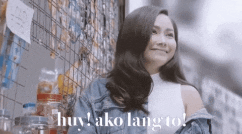 a woman in a denim jacket stands in front of a wire fence with the words huy ako lang to on it