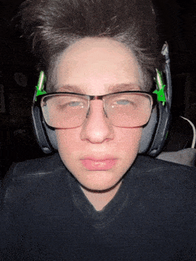 a young man wearing glasses and headphones is making a sad face