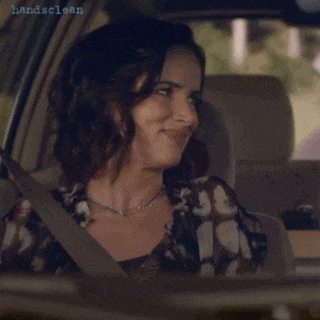 a woman is smiling while sitting in a car with handsclean written on the bottom right