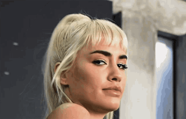 a close up of a woman 's face with a ponytail