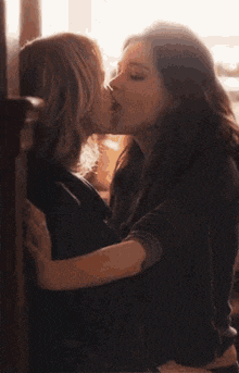 a couple of women hugging each other in a dark room