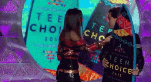 a man holding a surfboard that says teen choice 2015 on it