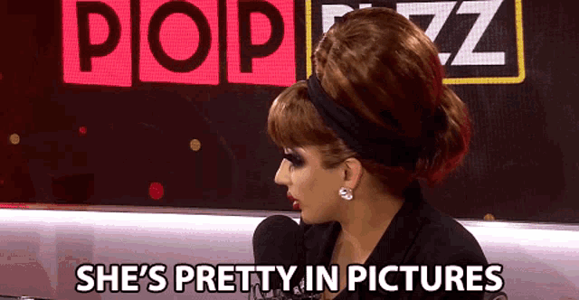 a woman says she 's pretty in pictures while sitting in front of a microphone