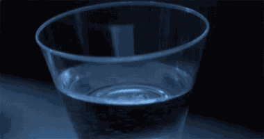 a clear plastic cup filled with water on a table .