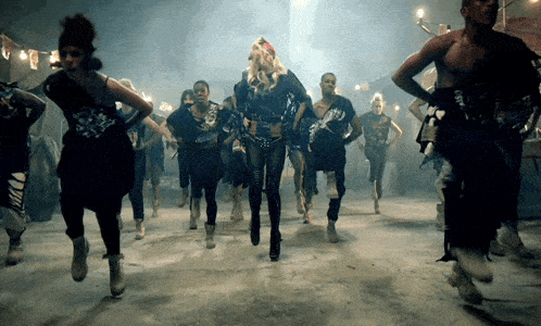 a group of people are dancing and one of them is wearing a t-shirt that says ' nirvana ' on it