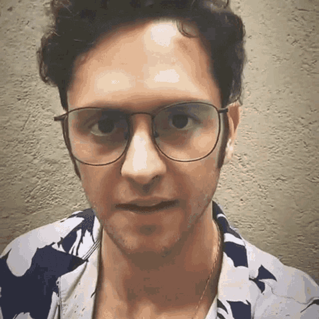a man wearing glasses and a blue and white shirt